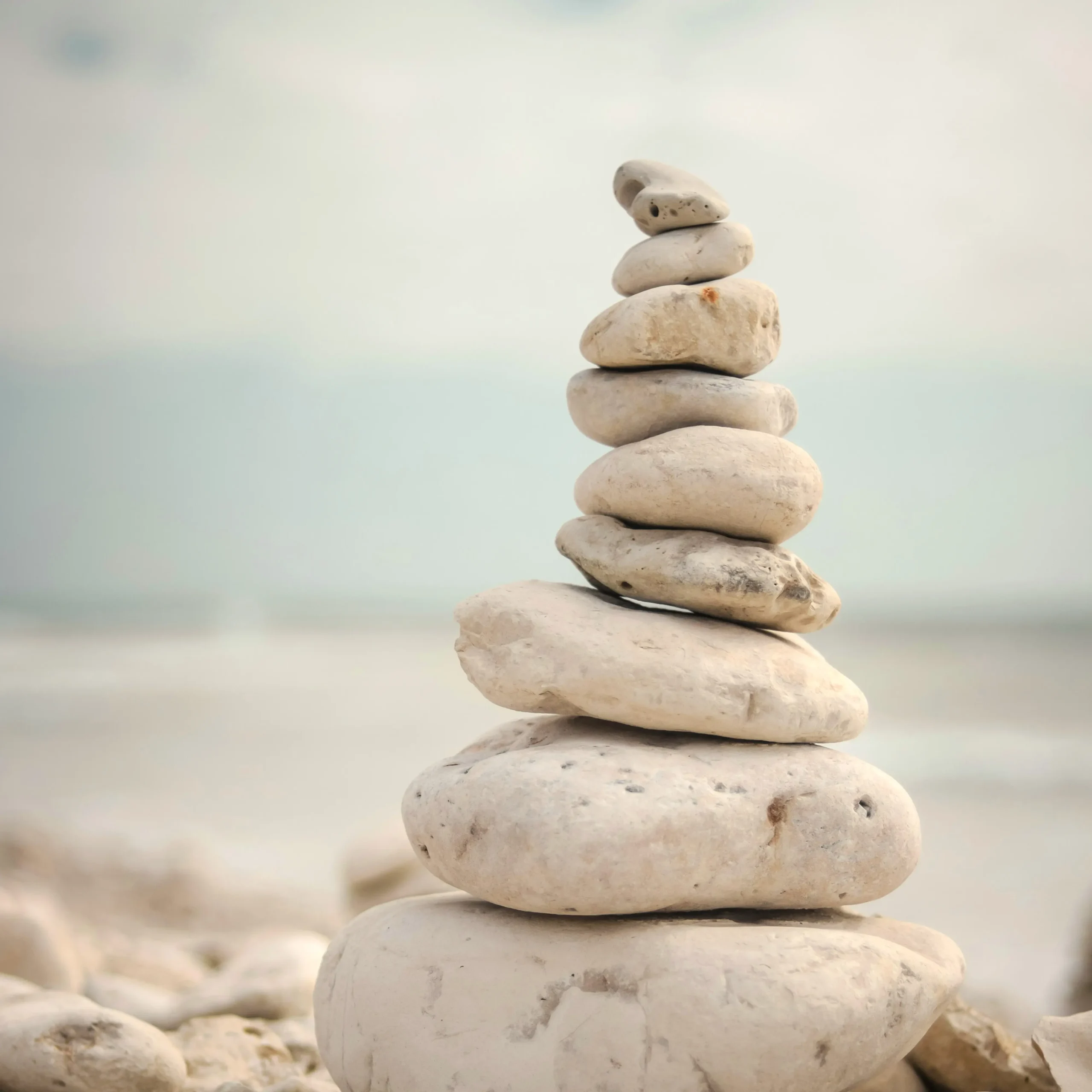 Stack of balanced stones on beach, representing balance and calm